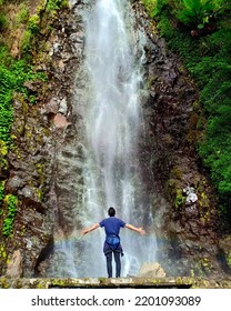 A man standing in front of a waterfall