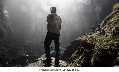 a man is standing with his back to the camera enjoying the view of the Tumpak Sewu waterfall, Lumajang, April 21, 2024