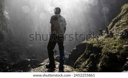 a man is standing with his back to the camera enjoying the view of the Tumpak Sewu waterfall, Lumajang, April 21, 2024