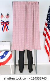 A Man Standing Inside A Voting Booth At His Local Polling Place. Vertical Format, Man Is Unrecognizable.