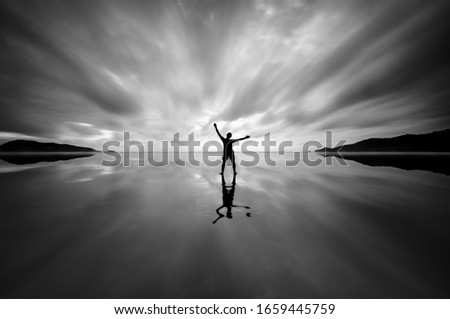 Similar – Hallig Gröde | Senior citizen stands in the calm North Sea at low tide and raises her hands to the sky