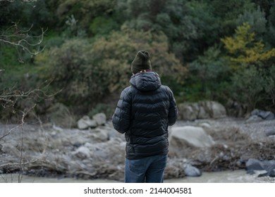 Man Is Standing And Looking At A Gorge Of Volcanic Origin With A River, Museum And Places For Rafting And Other Entertainment. Cloudy Magic Nature Day In Sicily, Italy With No  People Around.