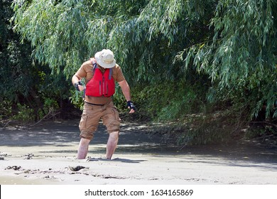Man Standing In Natural Quicksand River, Clay Sediments, Sinking, Drowning Quick Sand, Stuck In The Soil