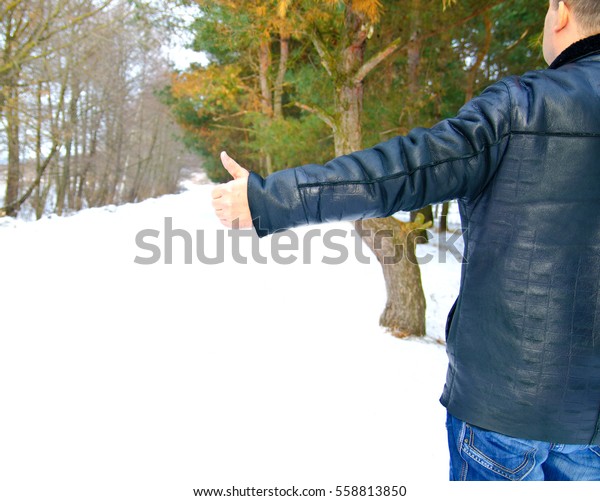 The man\
standing near the forest and catching the\
car