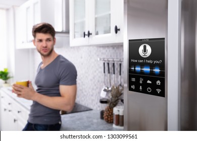 Man Standing Near Oven With Voice Recognition Function In Kitchen