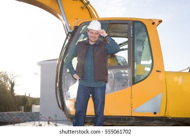 A Man Standing Next To The Cab Of A Backhoe On A Construction Site