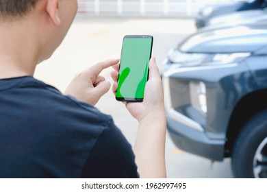 Man standing next to the car. man using smartphone mockup green screen near the car. Mobile phone apps for car lock owners concept.