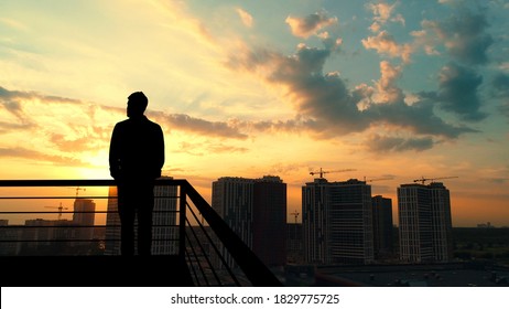 The man standing on the balcony on the building background - Shutterstock ID 1829775725