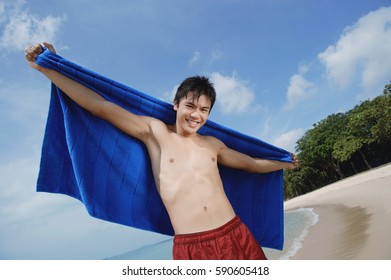 Man Standing On Beach, Holding Towel