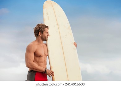 Man standing on the beach with surfboard enjoying the view - Powered by Shutterstock