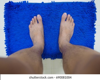 Man Standing On The Blue Mat Before Take A Shower/bath 