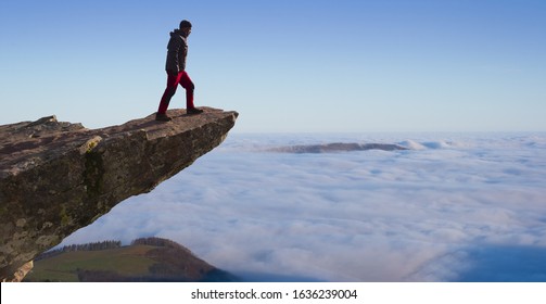 man standing on the cliff above the mountains and clouds - Powered by Shutterstock