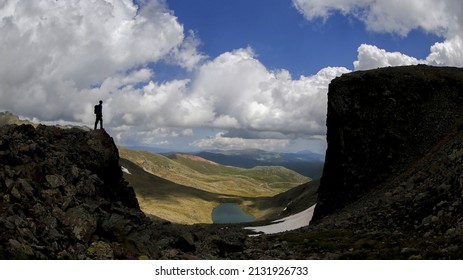 A man standing on the edge of a cliff beside a chasm - obstacles concept