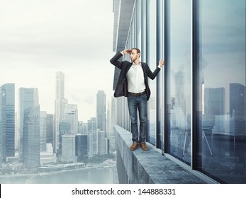 Man Standing On The Edge And Looking At The City