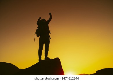 Man standing on edge of mountain feeling victorious with arms up in the air. Victory. Success, life goals. - Shutterstock ID 1474612244