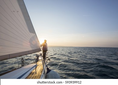 Man Standing On Front Of Luxury Yacht In Sea - Powered by Shutterstock