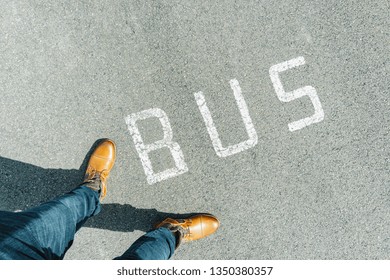 Man Standing On Grunge Asphalt City Street With White Text Bus, Point Of View Perspective