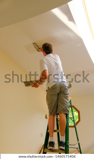 Man Standing On Ladder Repairing Cracks Stock Photo Edit