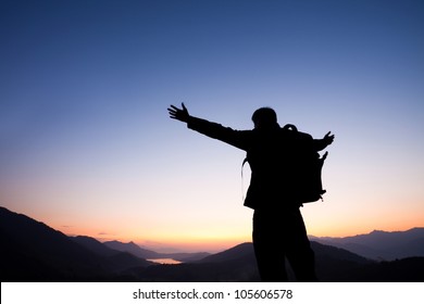 Man standing on the mountain with his arms wide open