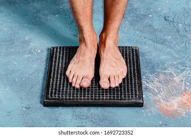 Man Standing On Natural Foot Wooden Massager With Hobnails, Spikes That Helps Blood Circulation. Recommended By Natural Way Of Distressing.
