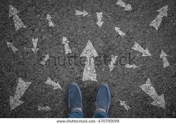 man standing on road with\
many direction arrow choices or move forward. concept solution and\
start.