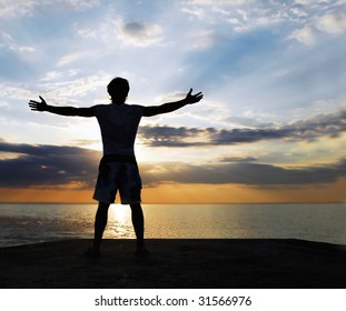 Man Standing On The Rock With His Arms Wide Open