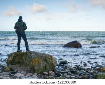 Man Standing On Rock In The Middle Of Ocean.  Tourist Stand Alone On A Rock And Watching Sea Horizon Within Sunset