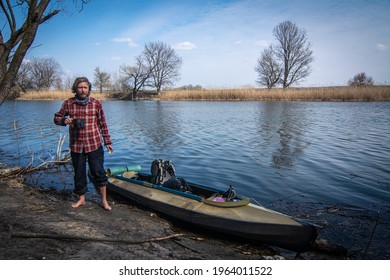 Man Standing On A Shore Near Kayak