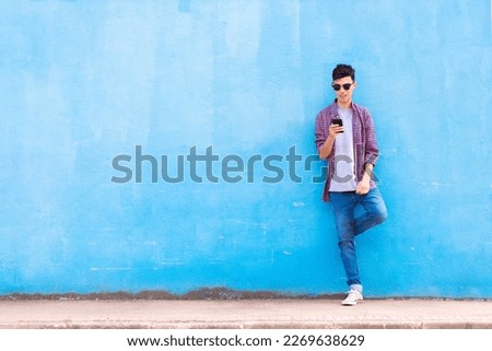 Similar – Image, Stock Photo Hispanic guy leaning on hand sitting against colorful illumination with opened mouth