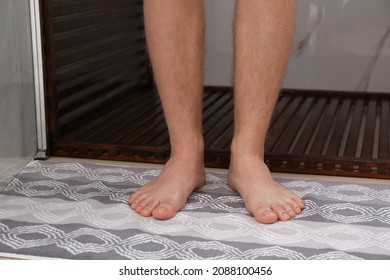 Man Standing On Stylish Mat Near Shower Stall In Bathroom, Closeup