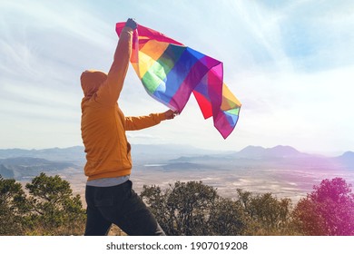 Man Standing On Top Of The Hill And Holding The LGBT Pride Flag