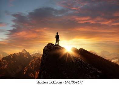 A man standing on top of a mountain as the sun sets. Goals and achievements concept photo composite. - Powered by Shutterstock