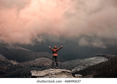 Man standing on the top of the mountain over sunset sky - Shutterstock ID 468490637