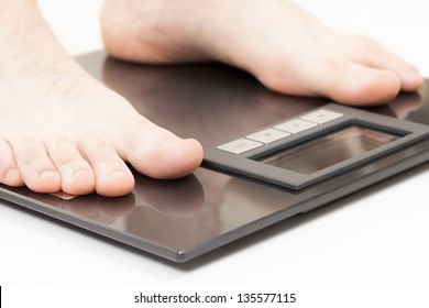 Man Standing On Weight Scales With Bare Foot