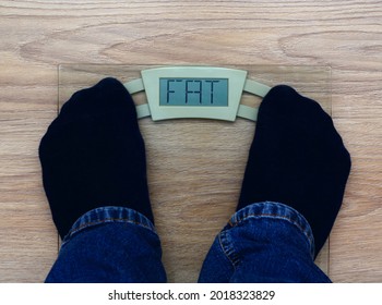 Man Standing On Weight Scales With Fat Inscription. Concept Of Fat Shaming.