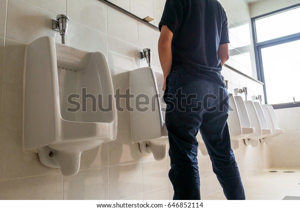 公衆トイレの中でおしっこをする男性 の写真素材 今すぐ編集