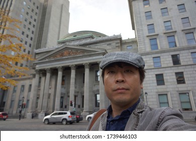 a man standing at place d’armes in front of bmo bank of montreal at rue saint jacques in montreal city of quebec, canada
