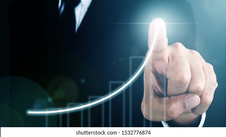 Man standing and pointing hand with Bar Chart and Line Visual Graphic on Light of Len flare and Bokeh blue background. COPY SPACE. Business Concept : Market Uptrend. - Shutterstock ID 1532776874