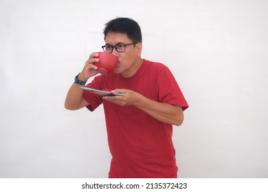 Man Standing And Sipping Soup From Red Wooden Bowl