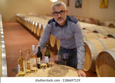 Man Standing In Winery Around Table