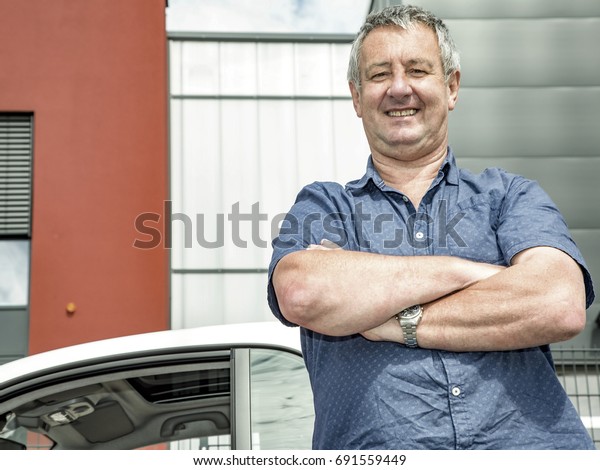Man stands in front of\
car\
