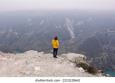 A Man Stands In The Mountains Looks Into The Distance. Tourist Back View. Time To Travel. Mood And Atmosphere Of Autumn Adventure. New Experience. Alone With Nature. Silence And Loneliness. Dagestan