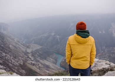 A Man Stands In The Mountains Looks Into The Distance. Tourist Back View. Time To Travel. Mood And Atmosphere Of Autumn Adventure. New Experience. Alone With Nature. Silence And Loneliness. Dagestan