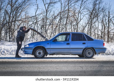 Man Stands Near His Broken Car In Winter