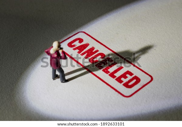 Man stands on cancelled stamp with dark shadow.\
Person is labelled or stereotyped. Cancel culture concept with\
noise and grain.