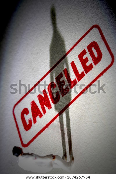 Man stands on cancelled stamp with dark shadow.\
Person is labelled or stereotyped. Cancel culture concept with\
noise and grain.