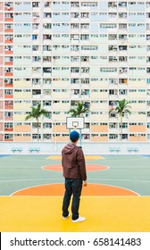 Man stands on Colorful Pastel Basketball Court with windows Background. Stock Photo