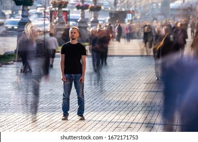 El hombre está parado en una calle concurrida