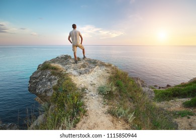 Der Mensch steht am Abgrund und blickt aufs Meer. Der Mensch entspannt sich in der Natur.