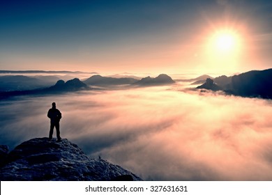 Man stands on the peak of sandstone rock in national park Saxony Switzerland and watching to Sun. Beautiful moment the miracle of nature. Misty valley. Man hike.Person silhouette stand.Foggy mountains - Shutterstock ID 327631631
